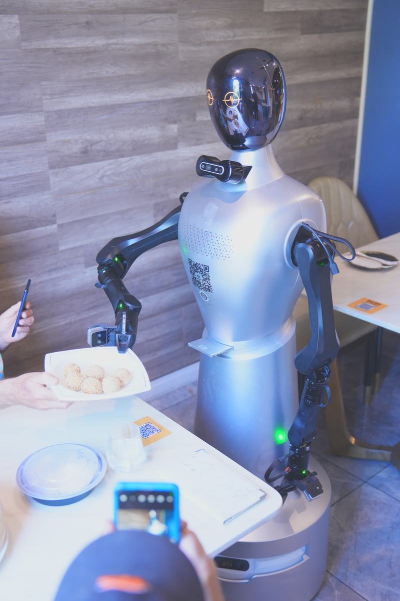 StarBot Nova handing a plate to a guest at the table